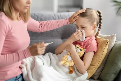 RS viry dítě nemocné smrká, matka drží teploměr a sahá holčičce na čelo