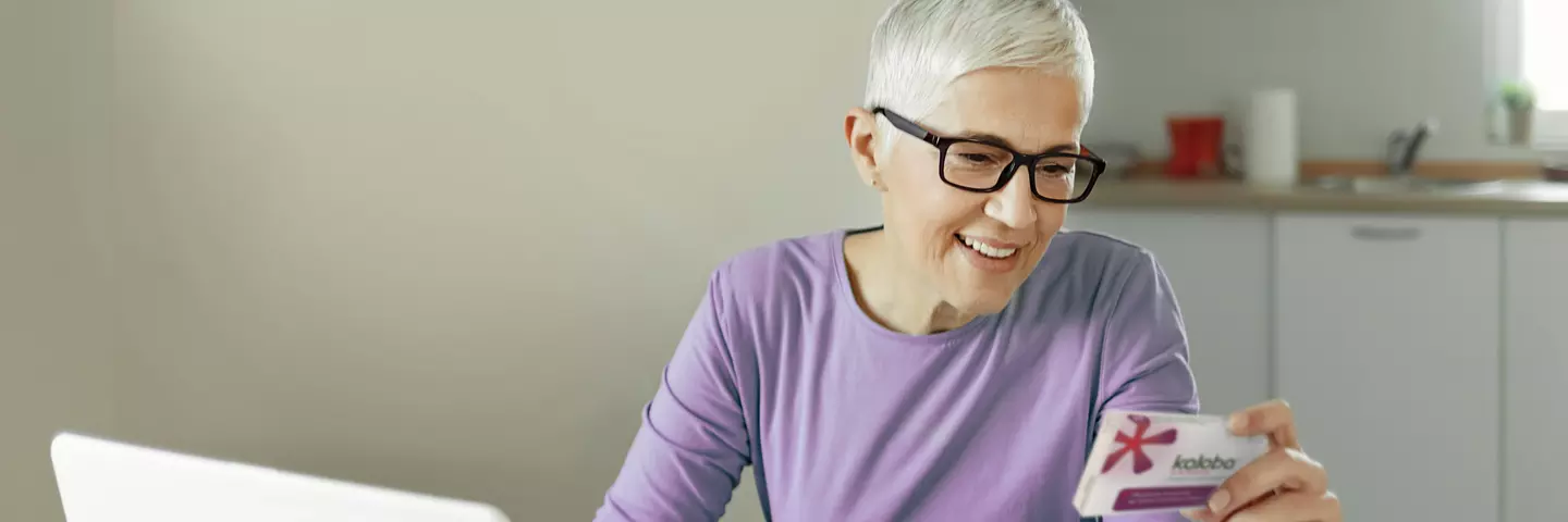 Žena se usmívá na lék Kaloba, který drží ve svý ruce