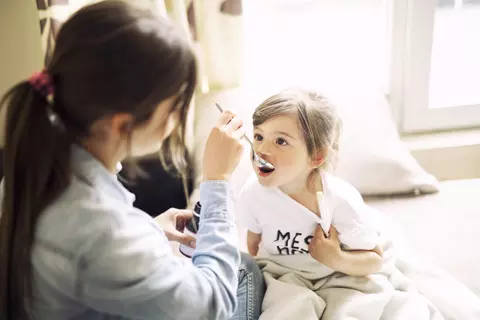 Matka podává lék dítěti