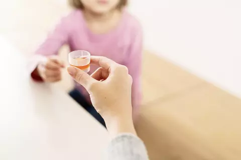 Ruka podávající Kaloba sirup dítěti